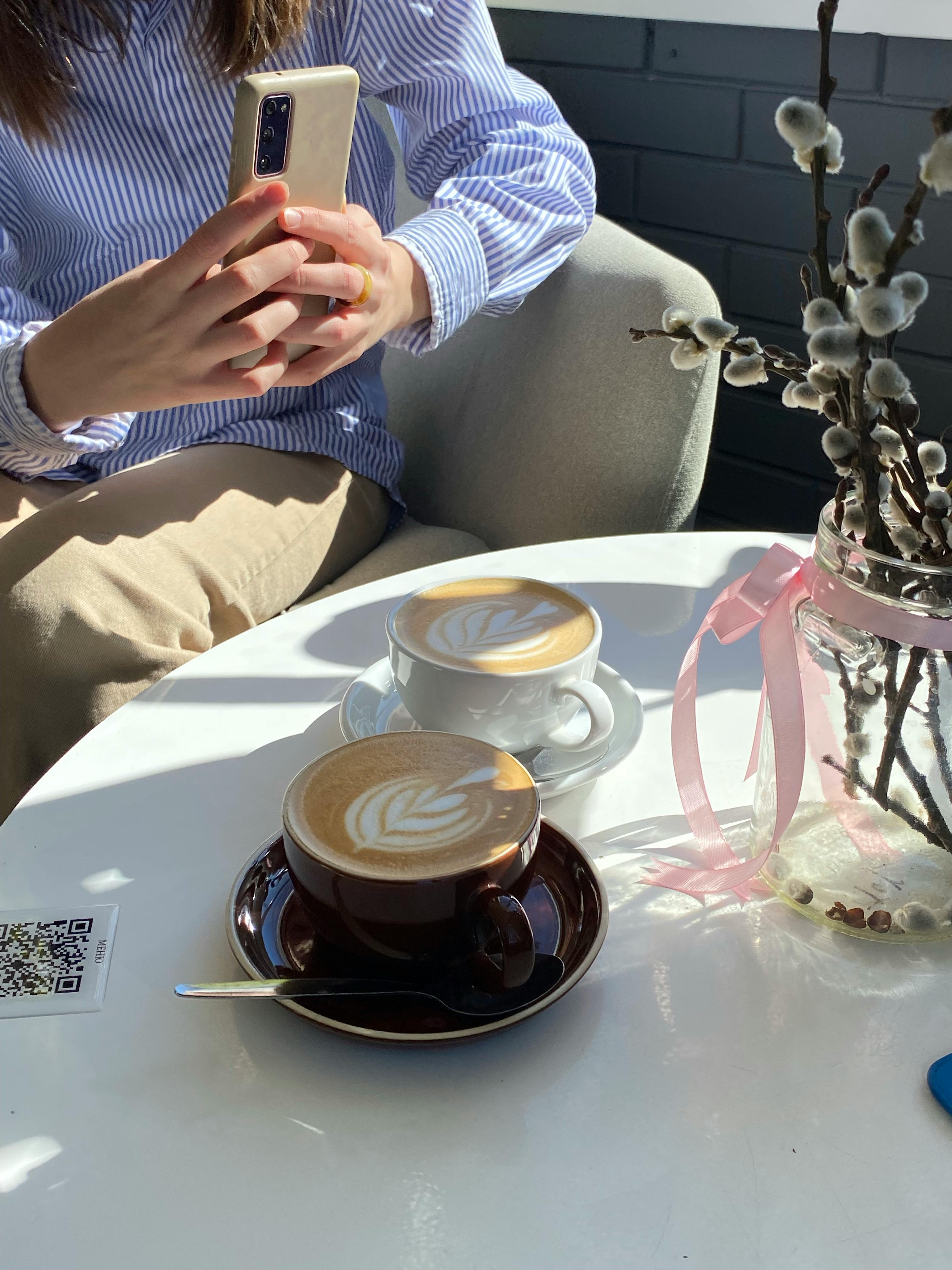 hands taking pictures of coffee on table