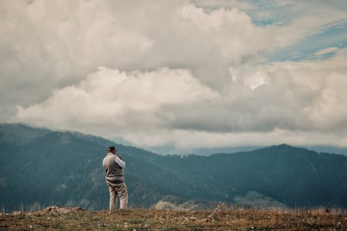 Free Hiker Standing on Hill and Looking at View Stock Photo