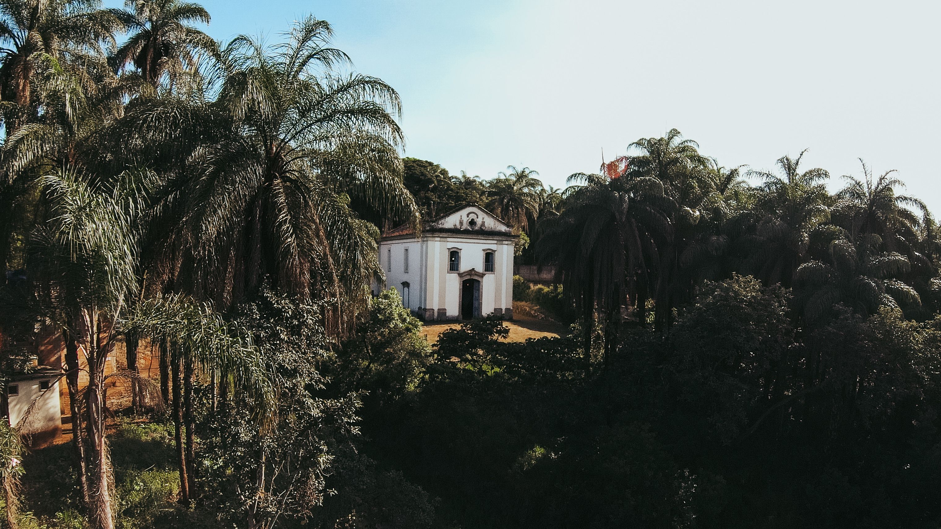 Charming colonial church nestled among tropical palm trees in Conselheiro Lafaiete, Brazil.