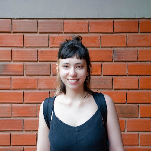Portrait of a Young Smiling Woman Wearing a Backpack 