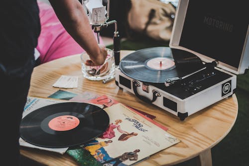 Free Person Near Vinyl Record Player on Brown Surface Stock Photo