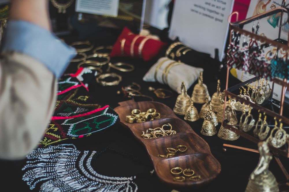 A spread of gold jewelry laid out on a warm wooden display tray