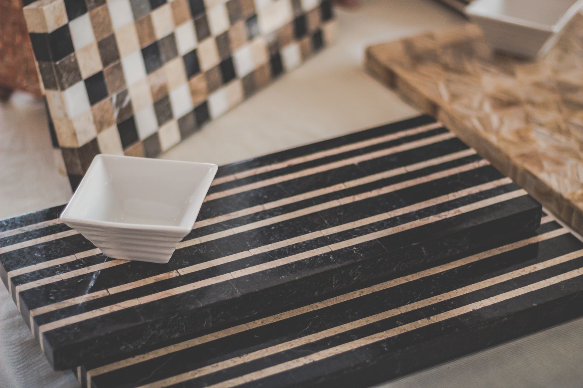 Stylish granite cutting boards with a modern striped design and a minimalist white square bowl.