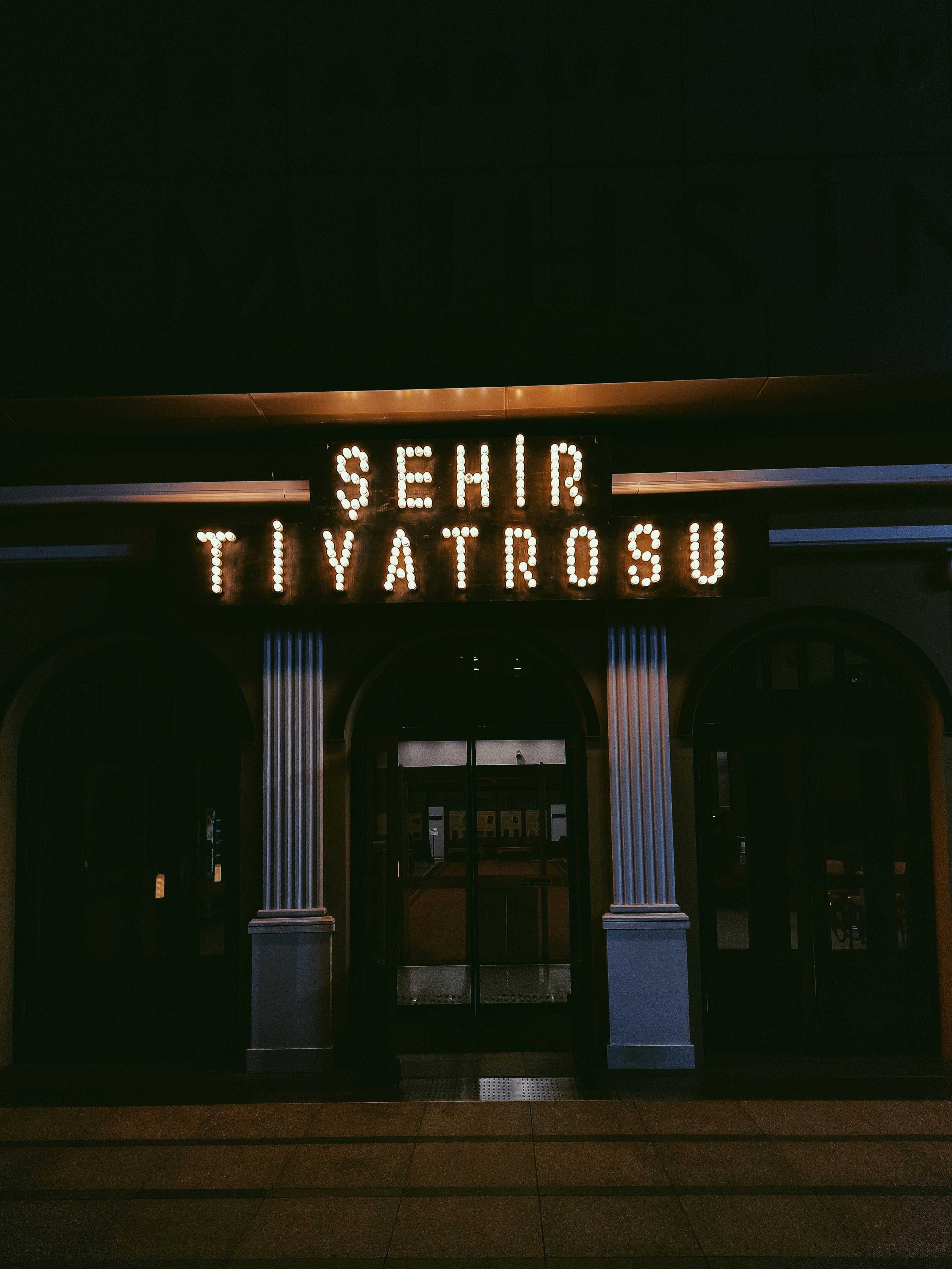 Free A glowing entrance of a city theater with neon lights at night. Stock Photo