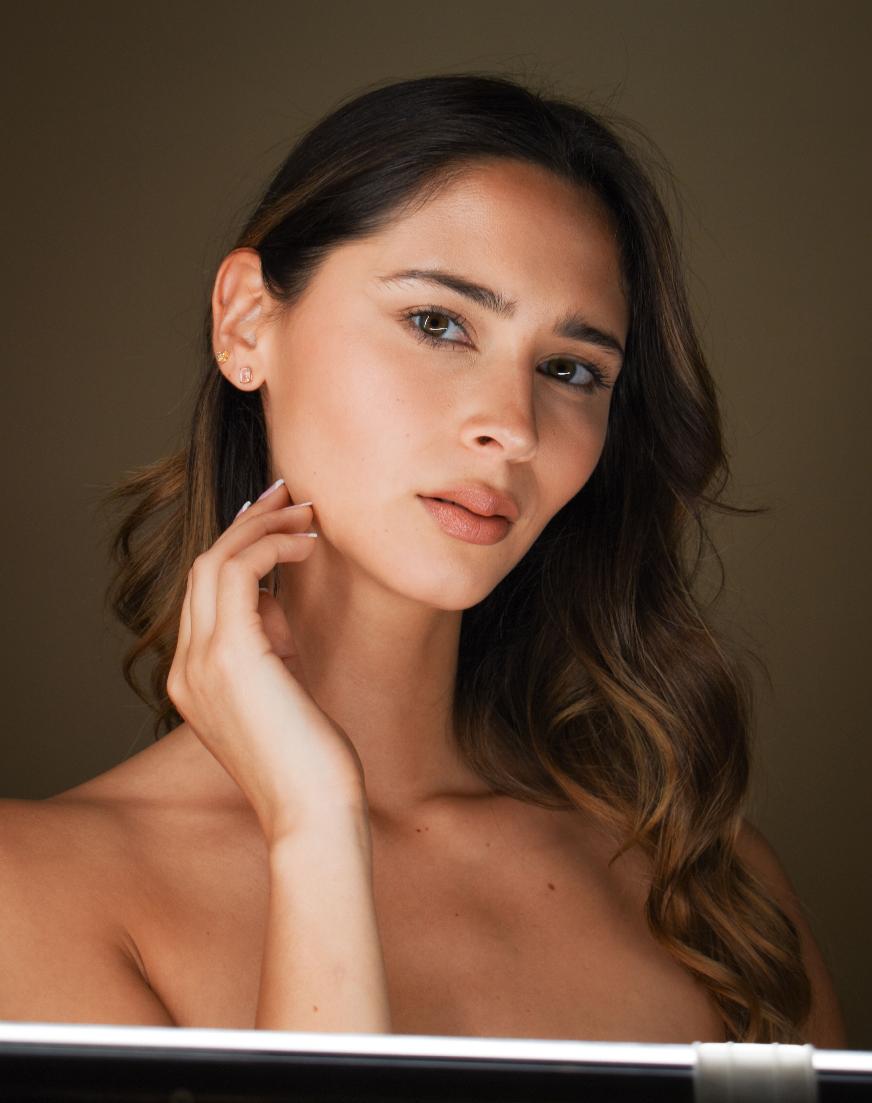 Elevating beauty in a subtle glamour portrait of a brunette woman with elegant poise.