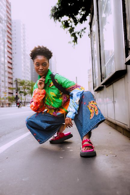 Model showcasing colorful streetwear in an urban setting.
