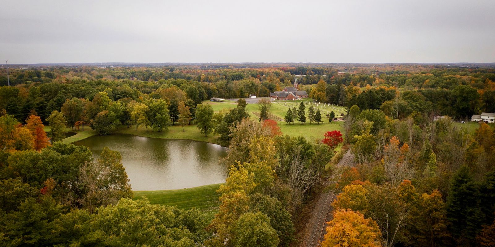 Aerial view of a river valley glowing with colorful autumn foliage