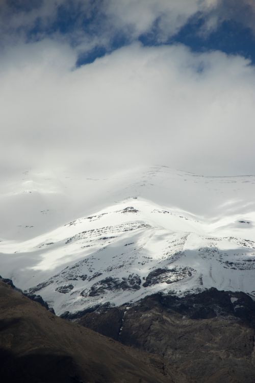Free A dramatic snow-covered mountain under a cloudy sky in Tehran, Iran, capturing the serene winter atmosphere. Stock Photo