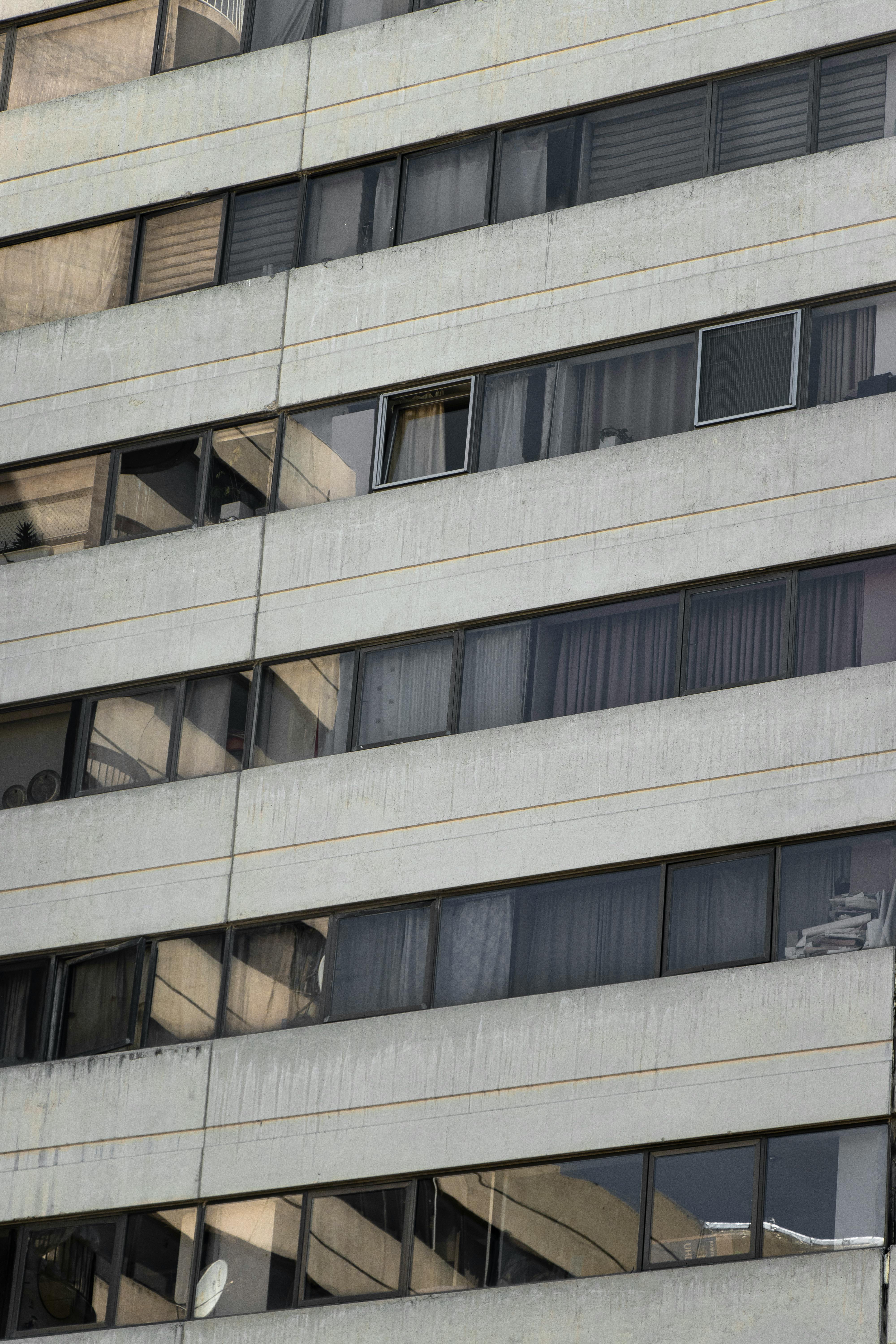 Detailed façade of a modern high-rise building in Tehran under a cloudy sky.