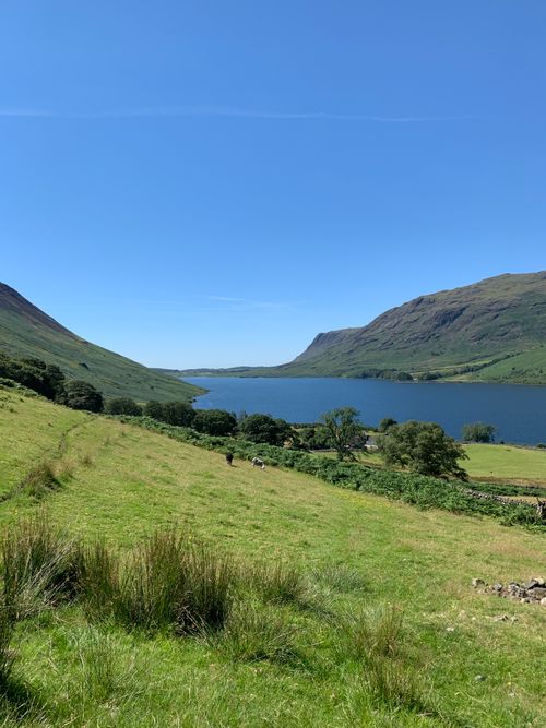 Free Explore the serene landscape of Wast Water in Cumbria, surrounded by lush green hills and a clear blue sky. Stock Photo