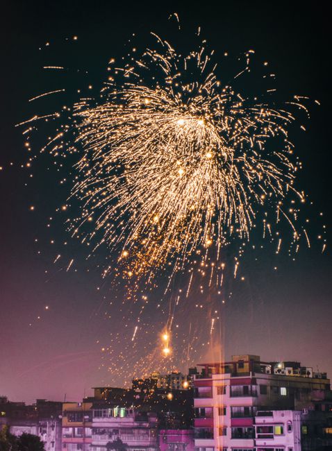 A vibrant fireworks display illuminates the city skyline, celebrating a festive occasion at night.
