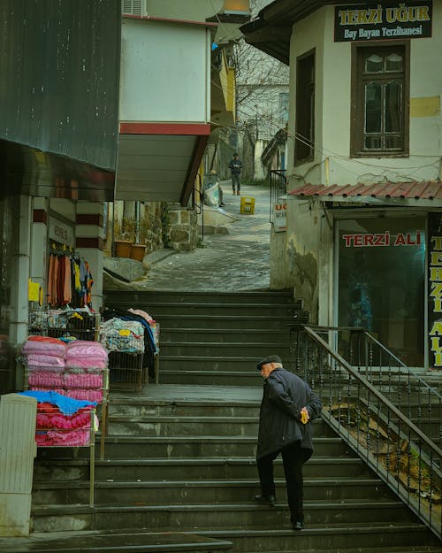 Elderly Man on Steps in Town