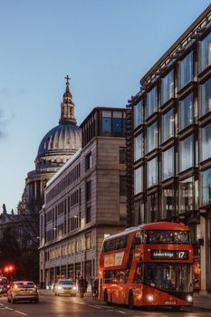 Scenic view of St. Paul's Cathedral dome and a red London bus at twilight in London, England.