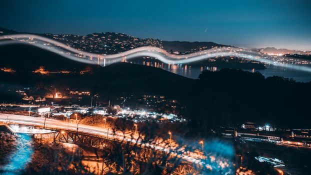 A stunning view of San Francisco at night featuring illuminated cityscapes and captivating light trails over the bay.