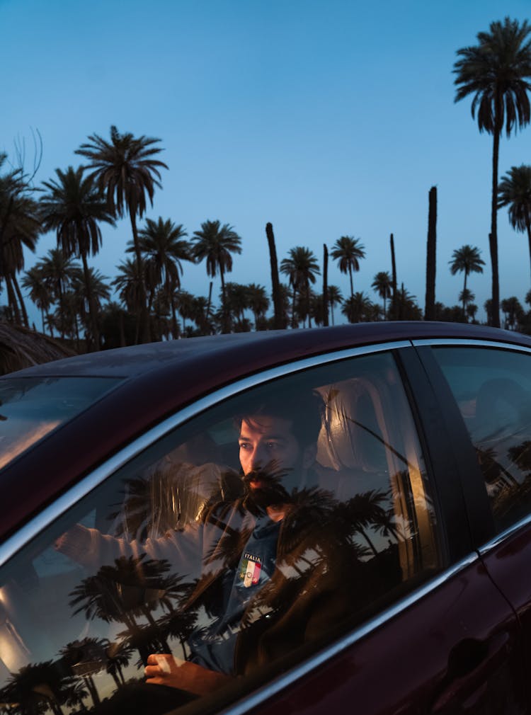 A Man Driving A Car In Sunset