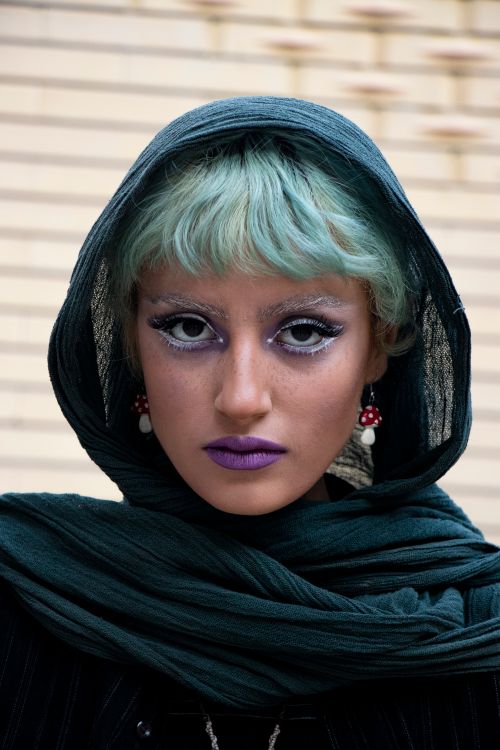 Free Dramatic portrait of a young woman with bold makeup and a green scarf. Stock Photo