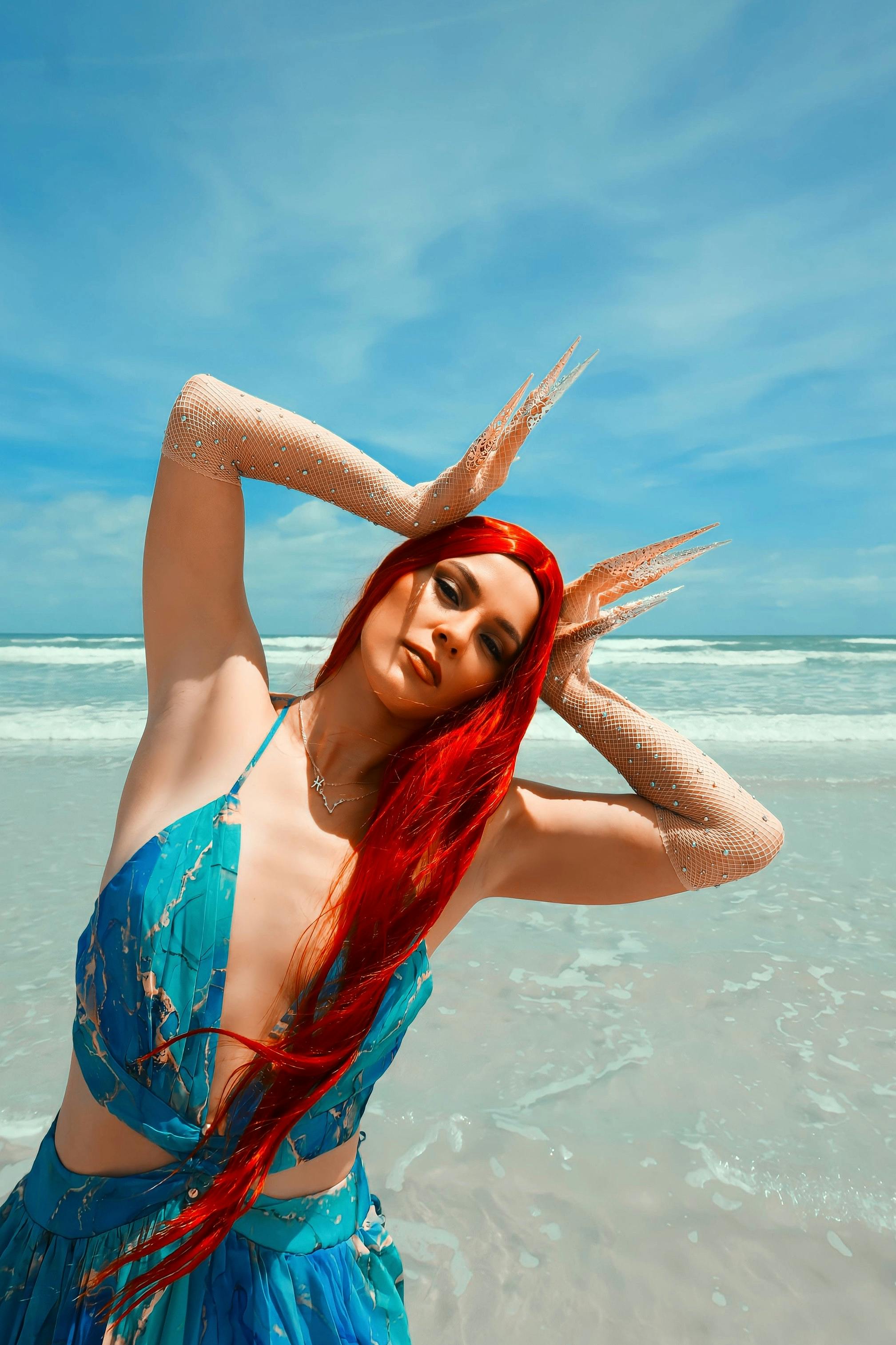 Captivating vibrant portrait of a woman in mermaid-inspired attire on a sunny beach.