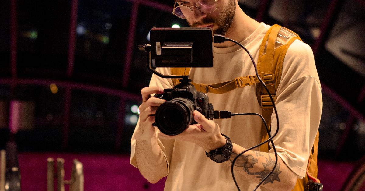 Operating A Camera A Fashionable Man Operating a Camera · Free Stock Photo