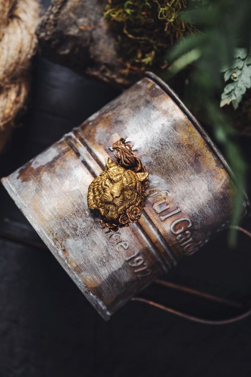 Free Close-up of a decorative lion key ring on a rusty metal can outdoors. Stock Photo