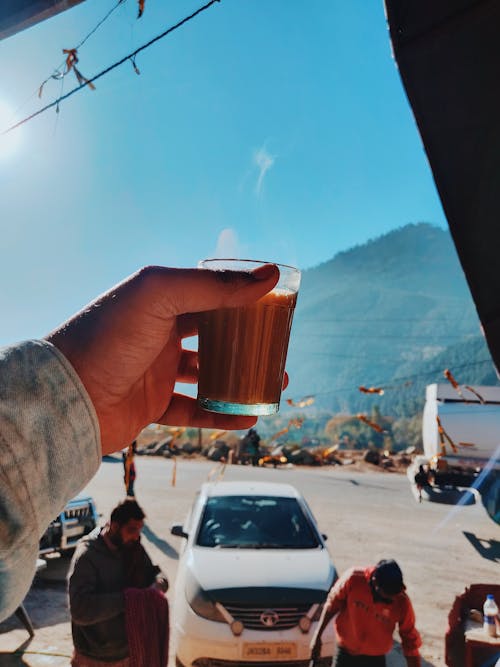 Person Holding Glass Cup Filled With Beverage