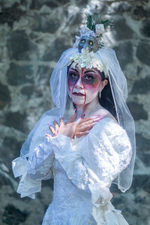 Free Gothic-themed Halloween bride with face paint and eerie costume outdoors. Stock Photo