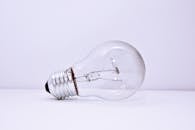 一个灯泡清晰地置于简洁的白色背景上，呈现出极简主义风格