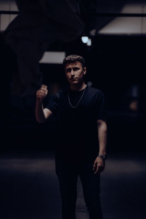 Free Moody night portrait of a man in a black t-shirt and necklace. Stock Photo