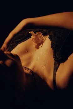 Sensual close-up of a woman in a lace bra with artistic lighting and shadows.
