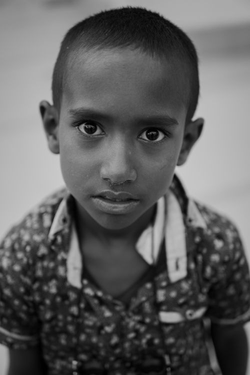Free Expressive monochrome portrait of a young boy in Sylhet, Bangladesh in a floral shirt. Stock Photo