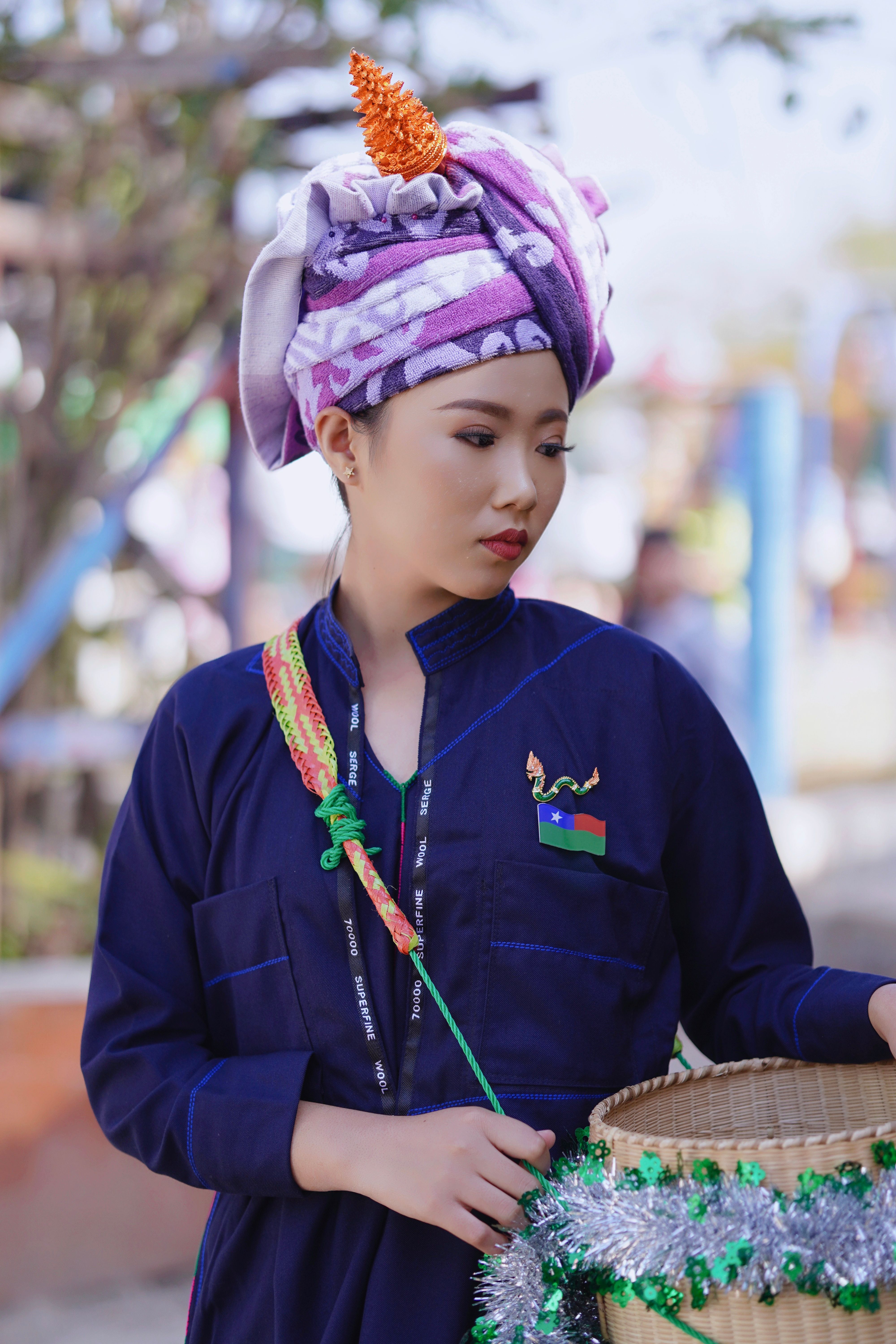 Portrait of an Asian woman in traditional attire during a cultural event outdoors.