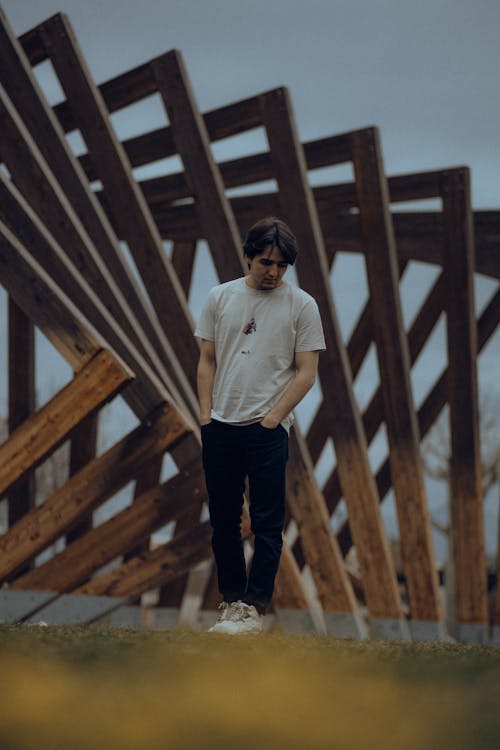 Man Standing against Modern Wooden Rural Structure