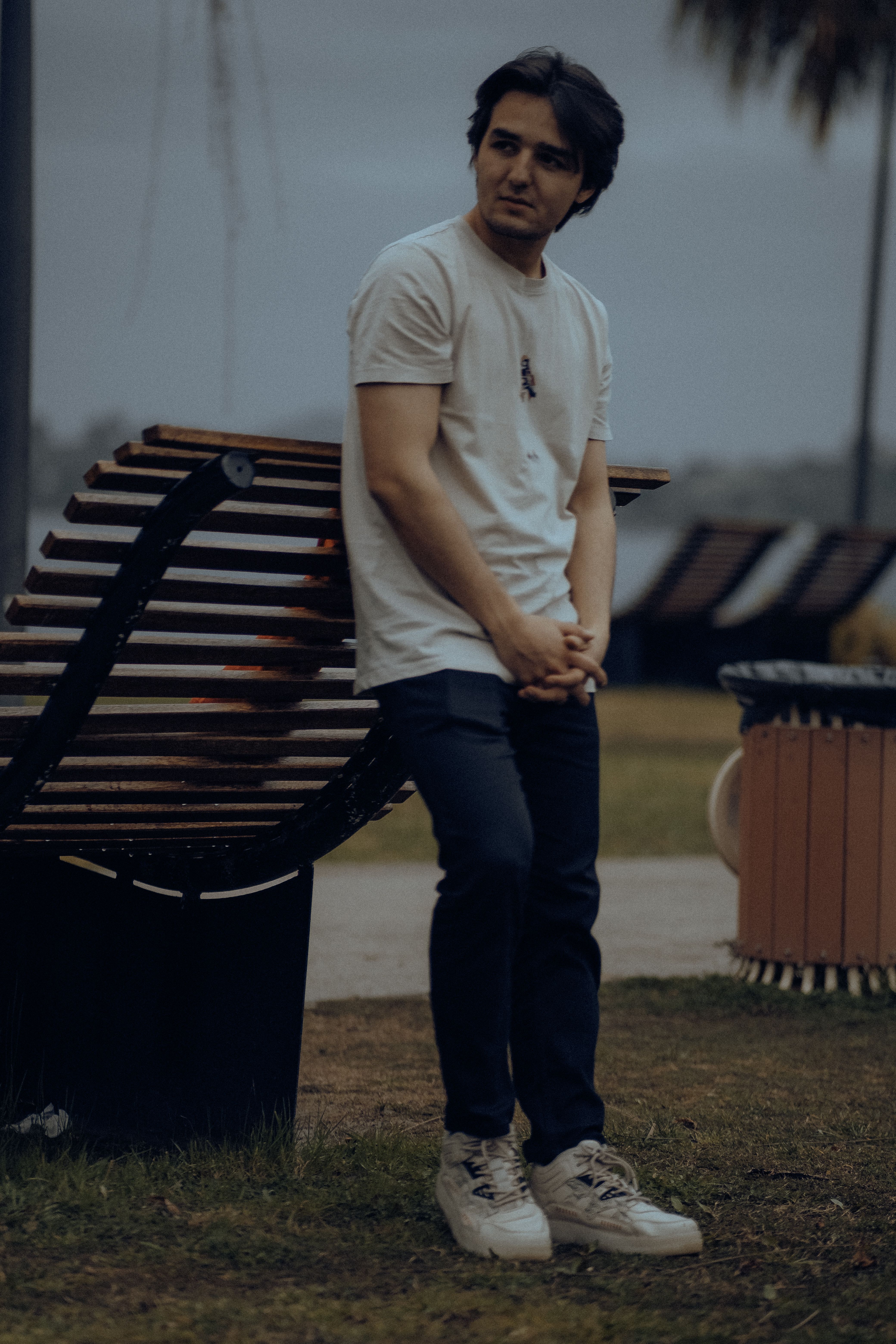 Man Leaning on Wooden Modern Bench · Free Stock Photo
