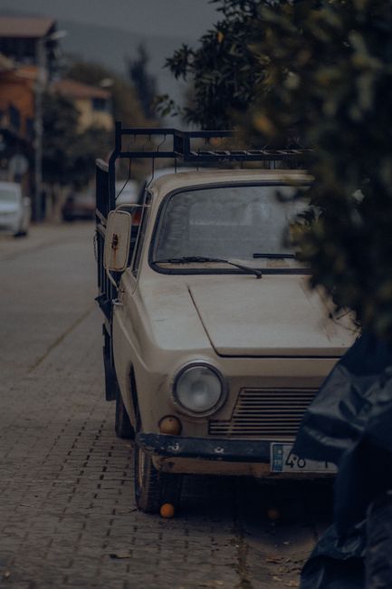 Fotomural Un coche retro estacionado en una tranquila calle de la ciudad, añadiendo un encanto nostálgico a la escena urbana.