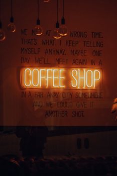 Moody interior with a neon coffee shop sign and reflective decor, perfect for lifestyle themes.