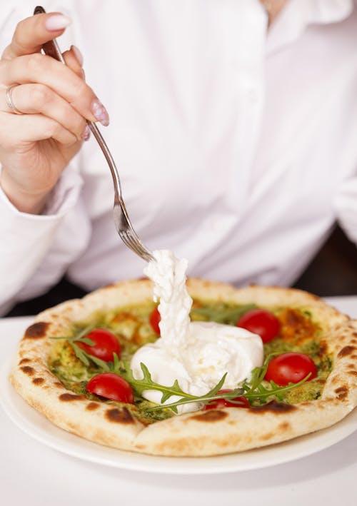 Person's Hand with a Fork over Pizza with Mozzarella