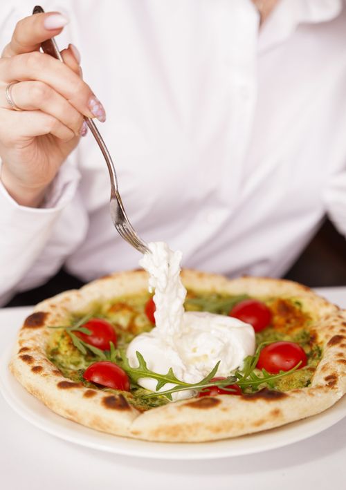 Free Savor this Italian delight featuring burrata cheese, cherry tomatoes, and fresh arugula on a gourmet pizza. Stock Photo