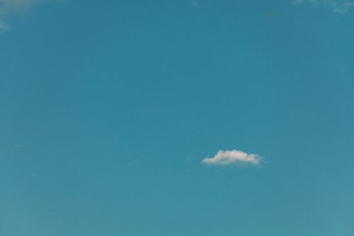 Free A tranquil blue sky featuring a single white cloud, epitomizing simplicity and serenity. Stock Photo
