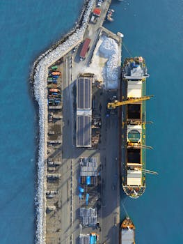 Aerial drone shot of a cargo ship docking at Marina di Carrara port in Tuscany, Italy.