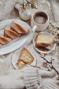 Warm morning scene of coffee and homemade cake slices on a cozy sweater.