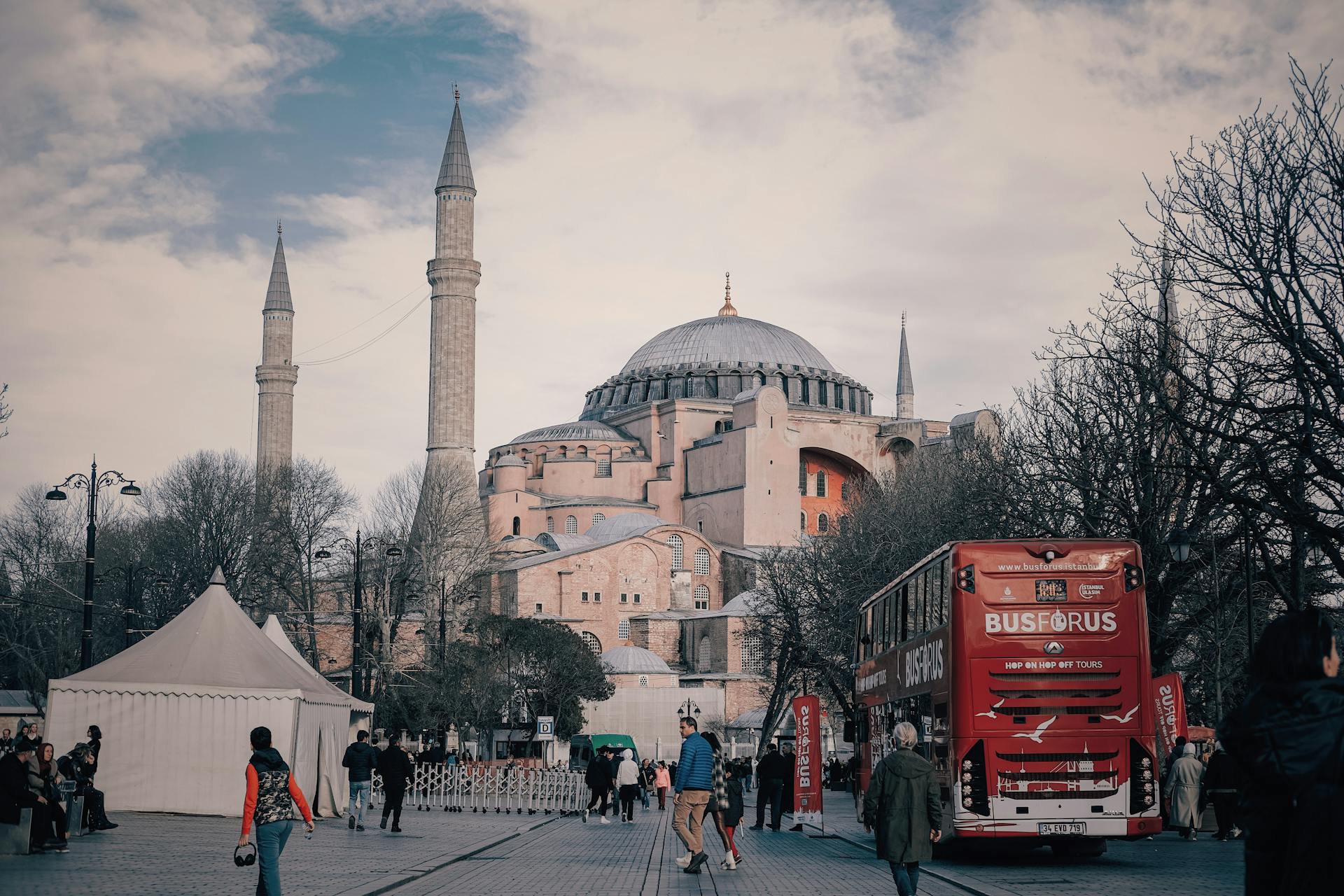 Hagia Sophia in Istanbul with people and a bus on a lively street.