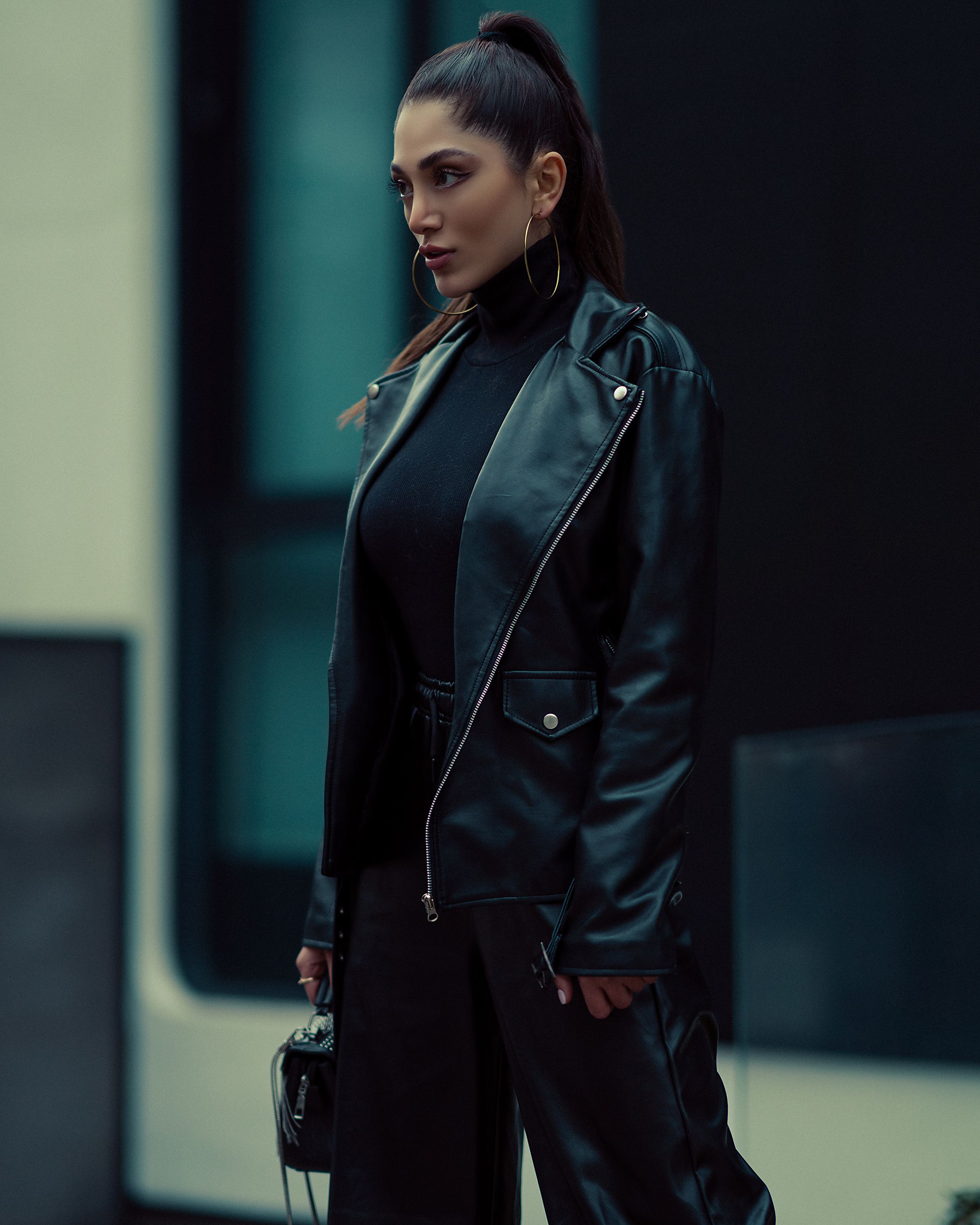 Woman in leather jacket with turtleneck and high-waisted trousers