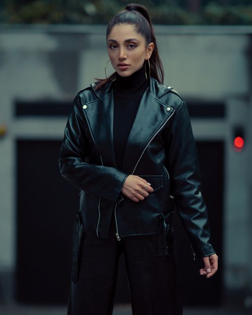 Free Fashionable woman in leather jacket posing outdoors with confident look. Stock Photo