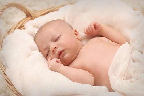 Free Baby Sleeping on White Cotton Stock Photo