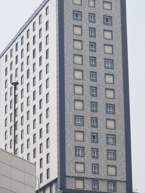 Free A tall, modern building with numerous windows in an urban setting. Stock Photo