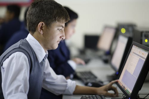 Young Man Using a Computer in a Classroom 
