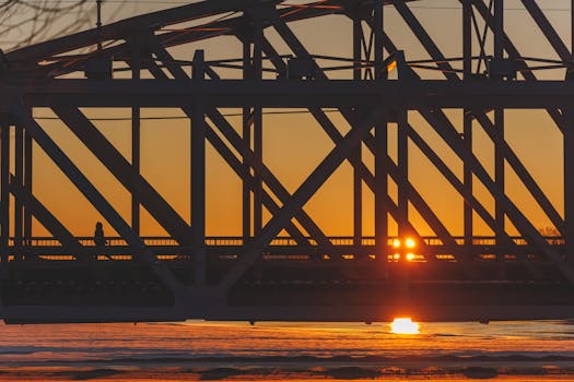 Steel bridge silhouette in Oulu, Finland with beautiful sunset reflection on the river.
