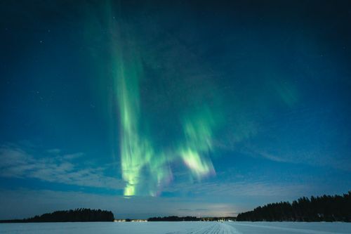 Free Stunning aurora borealis over snowy field in Vaala, Finland during winter night. Stock Photo
