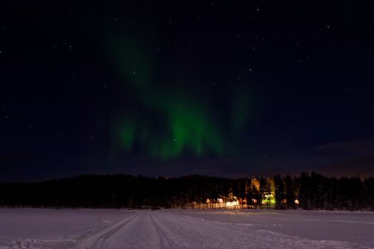 Beautiful aurora borealis illuminating a snowy landscape in Helukka, Finland.