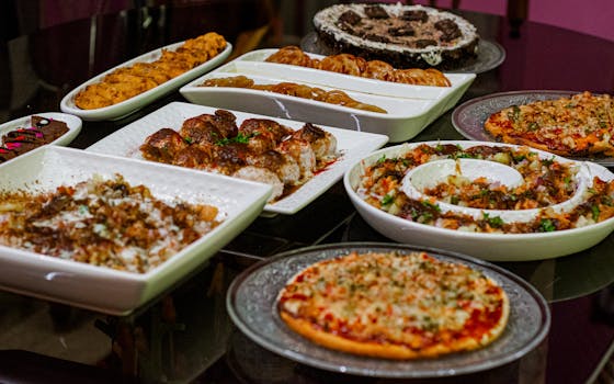 A variety of delicious dishes including pizza and desserts arranged on a dining table.