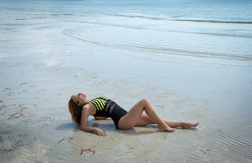 Woman in a Swimming Costume Lying on the Beach 